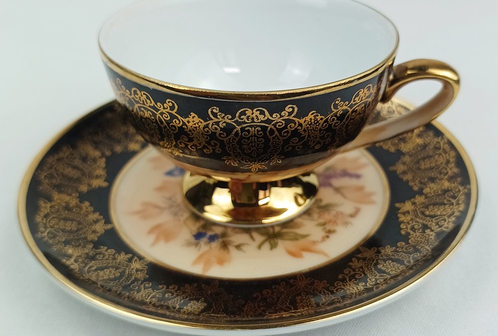 LO 100 – Xícara de cafezinho em porcelana ricamente decorada com flores e arabescos em ouro com fundo preto