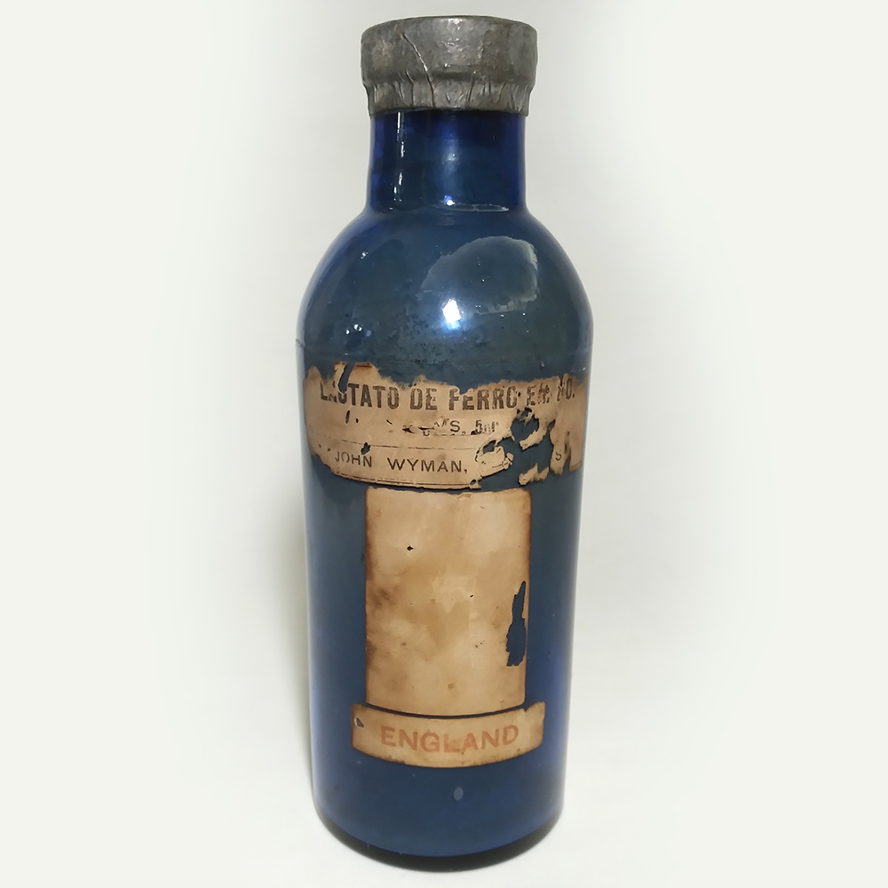 CR 59 – Frasco de farmácia antigo inglês em vidro azul com lacre de John Wyman