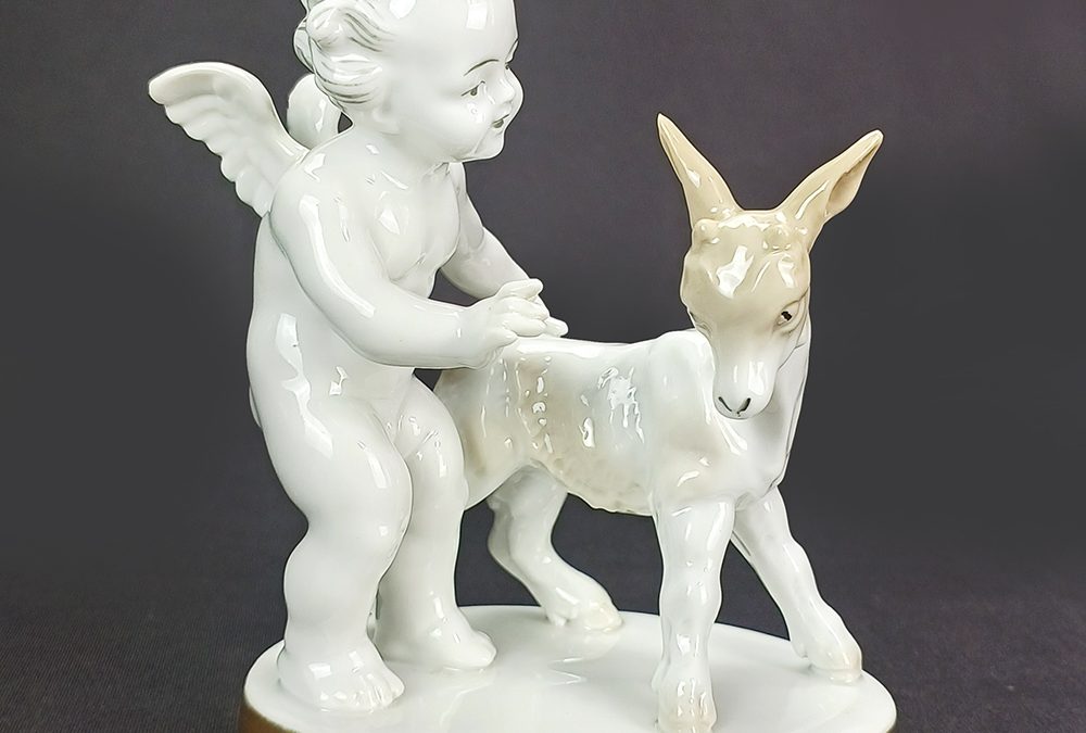 LO 07 – Bibelô ou escultura em porcelana alemã Kunstporzellan com anjo ou querubim e bode