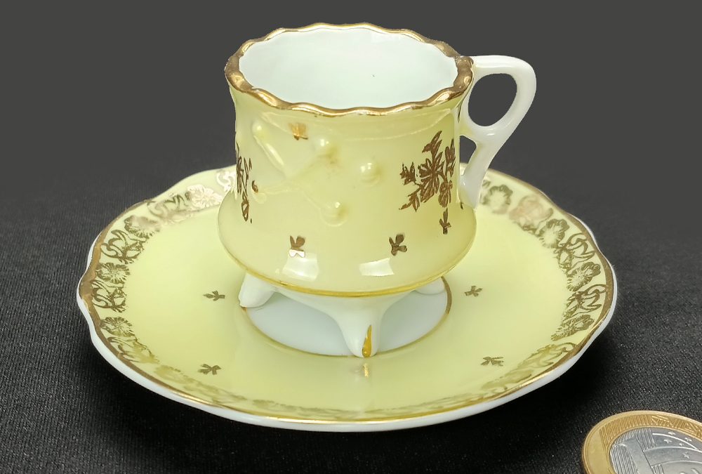 LO 141 – Xícara de cafezinho antiga em porcelana Schmidt amarela com pezinhos e dourados